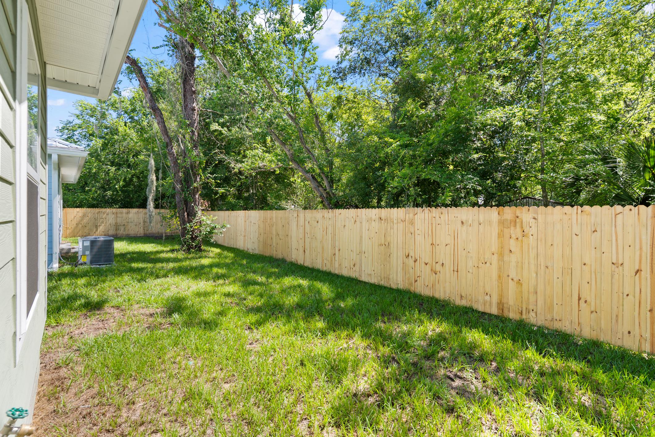 Fully fenced backyard with mature trees